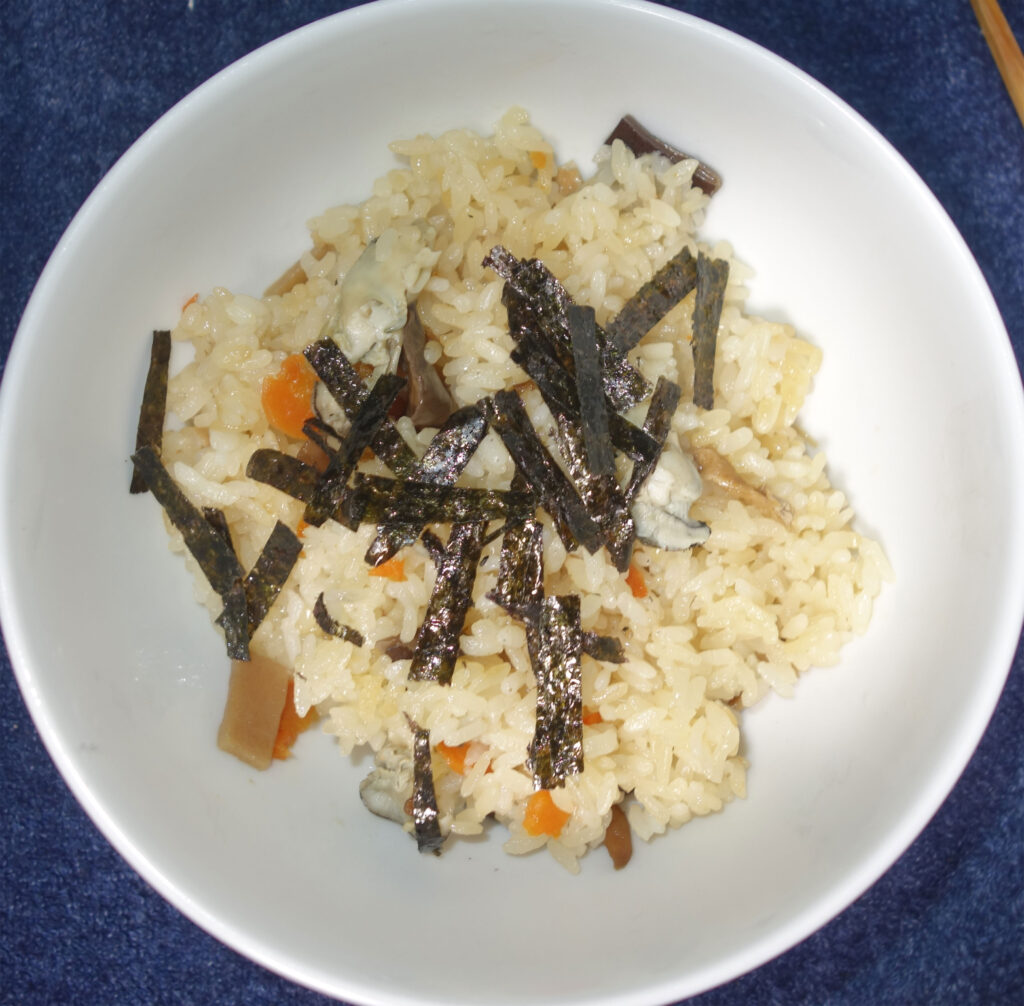 白いどんぶりのカキご飯に海苔