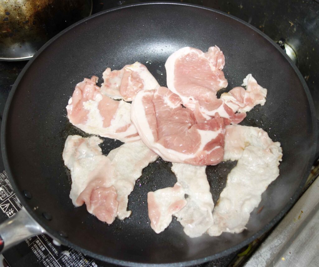 フライパンで豚肉を焼いている