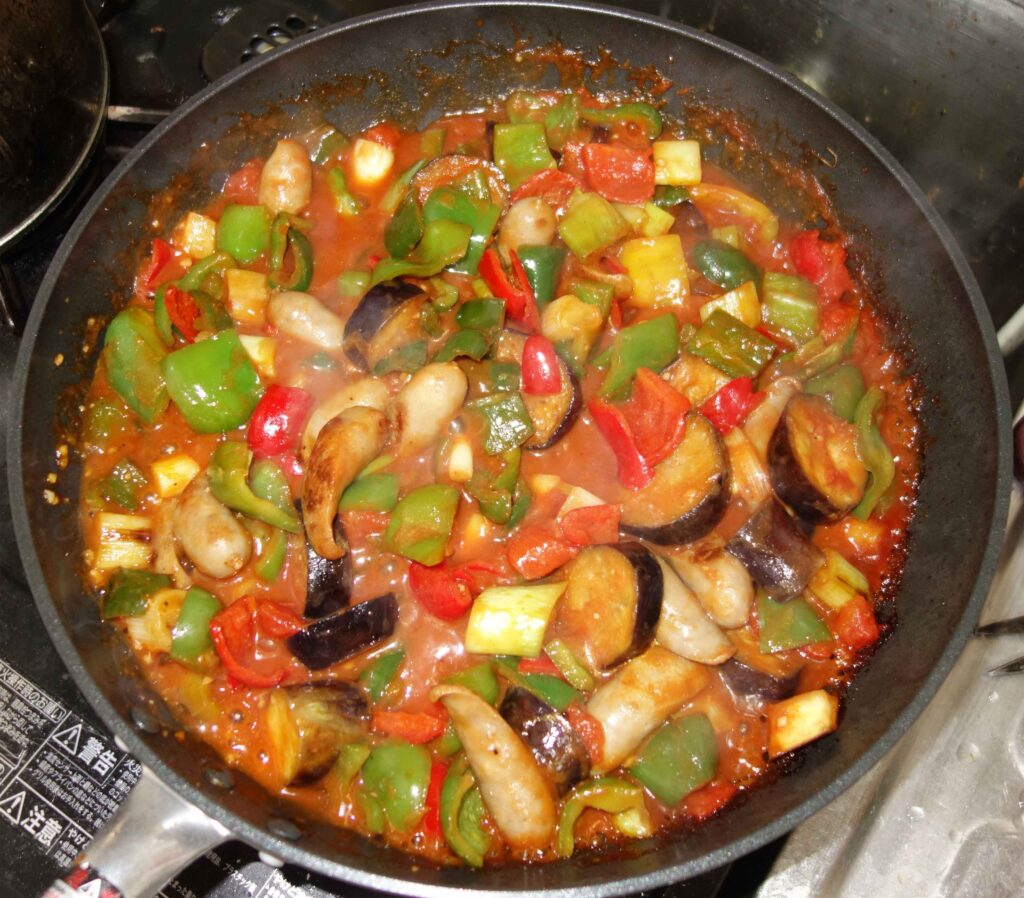 フライパンで調理された野菜とソーセージ