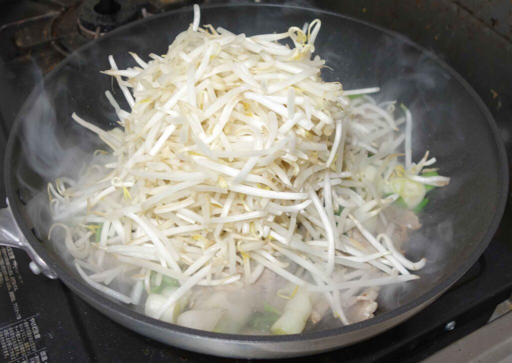 フライパンで豚肉ともやしを炒める