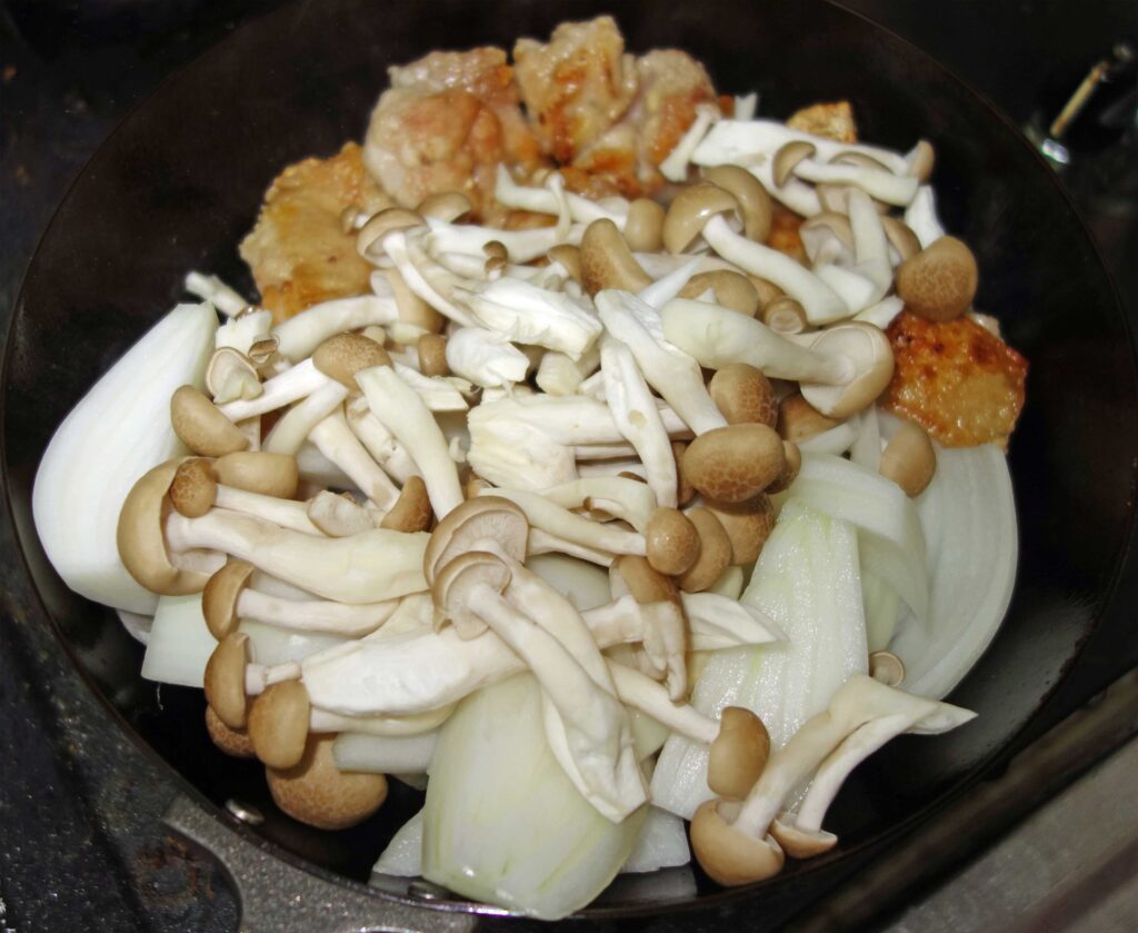フライパンで炒める鶏肉と玉ねぎとしめじ