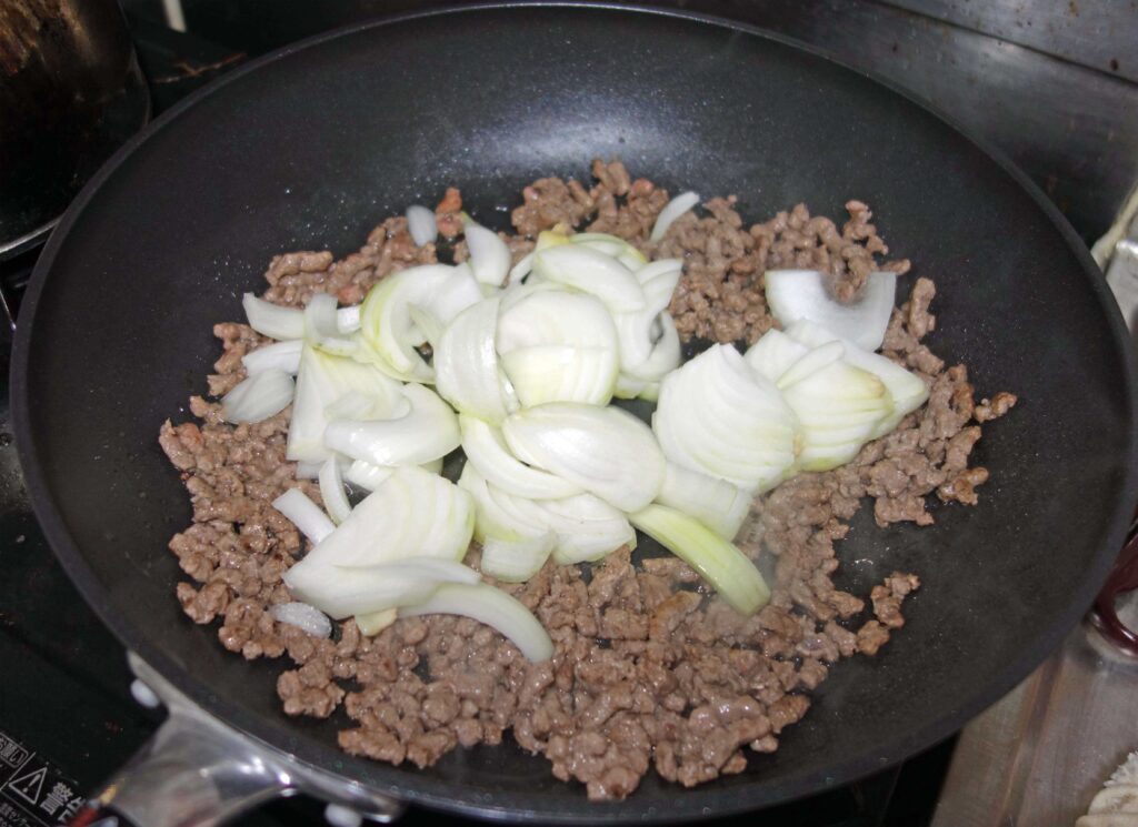 フライパンでひき肉と玉ねぎを炒めている様子