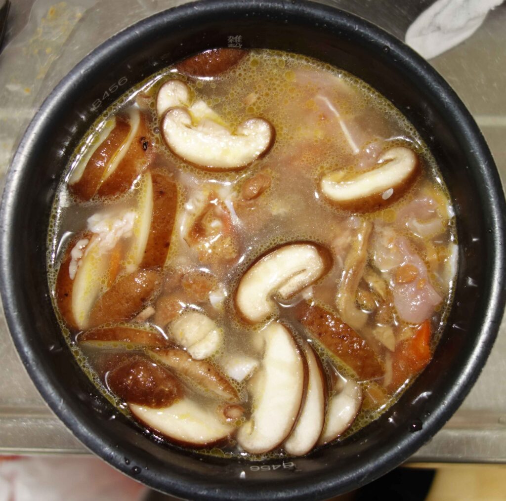 鍋に入ったキノコと鶏肉のおかゆ