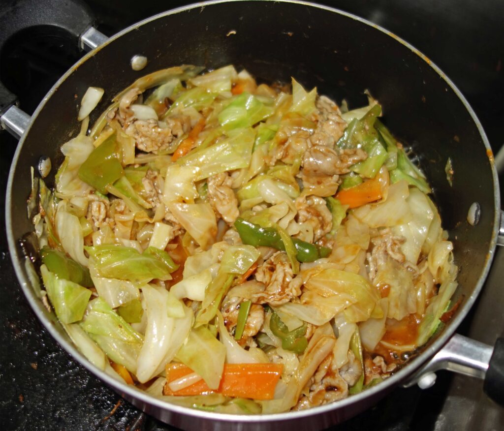 鍋で炒めた豚肉とキャベツ