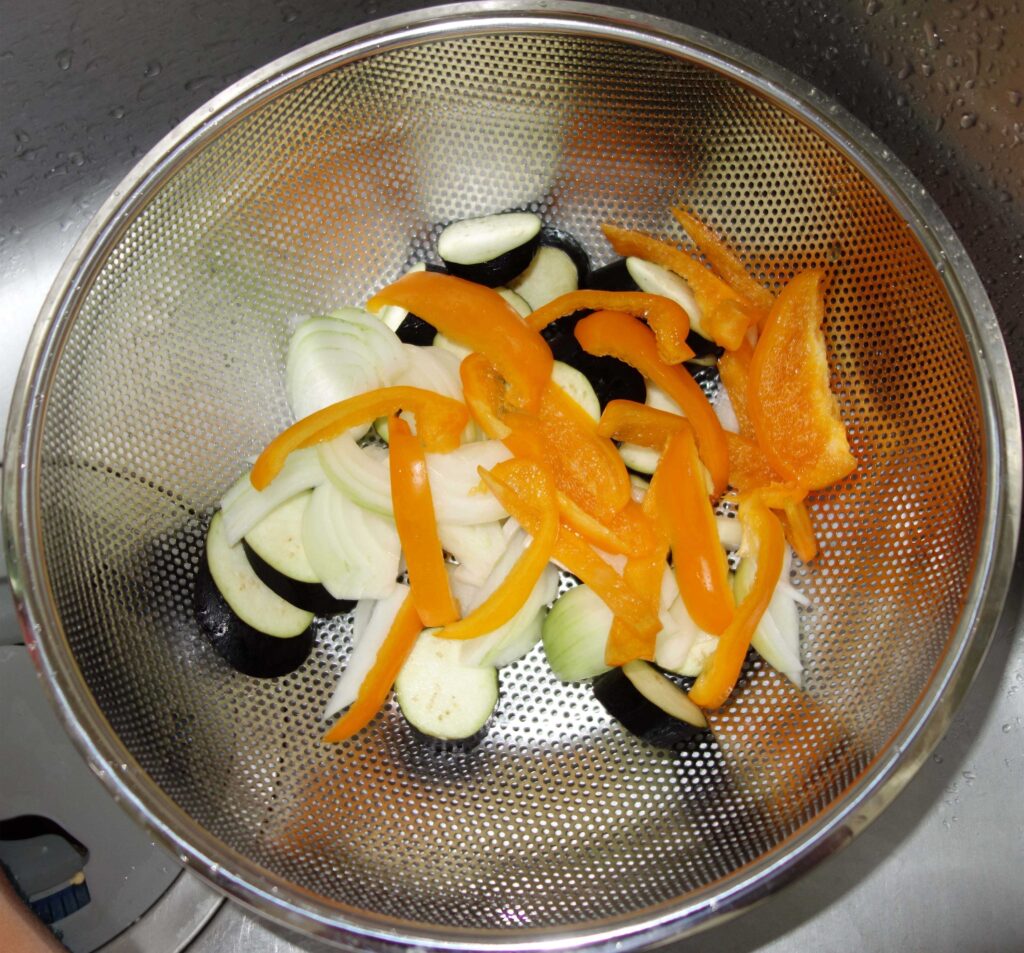 ざるに入ったナス、玉ねぎ、パプリカ