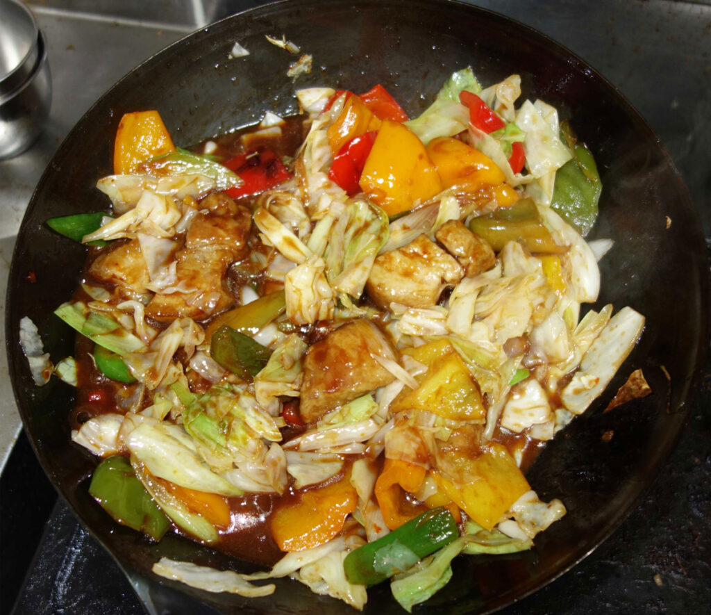 中華鍋で炒めた豚肉と野菜