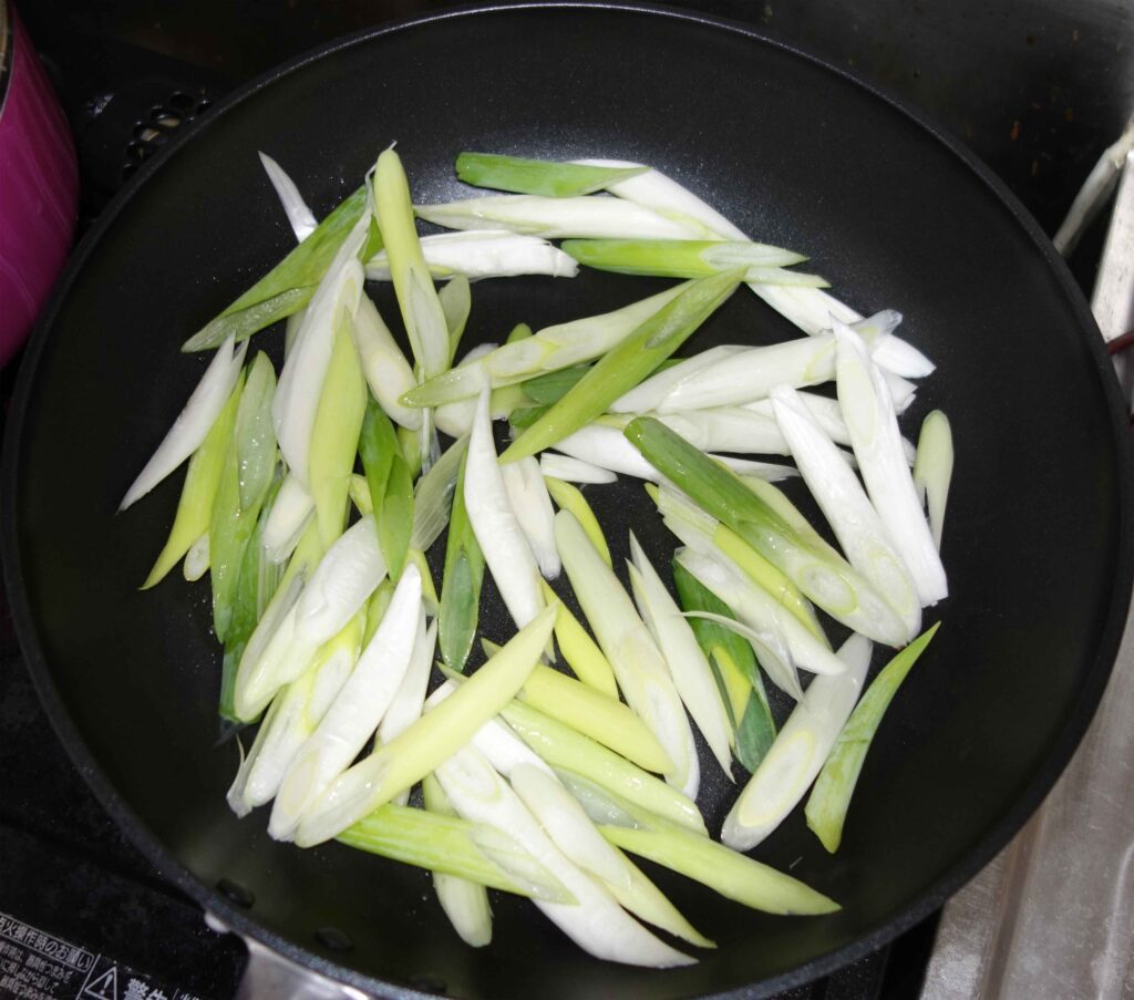 フライパンで炒めるネギ