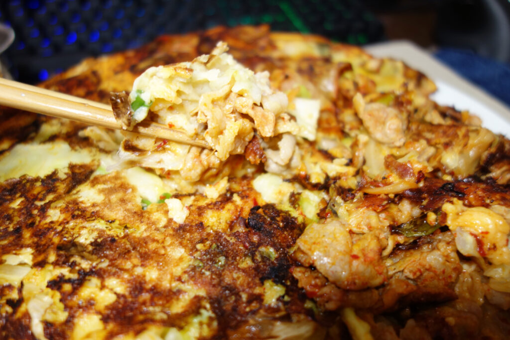 お好み焼きを箸で持ち上げている様子