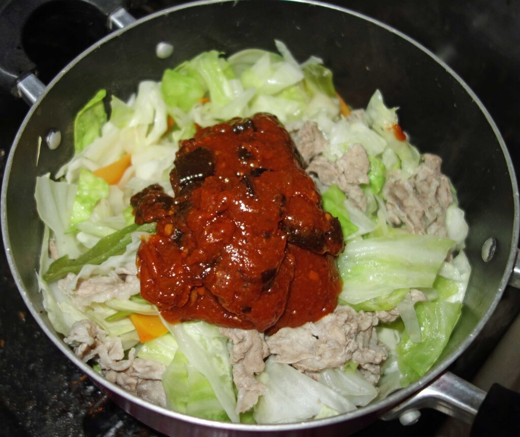 鍋で調理中の肉と野菜の炒め物