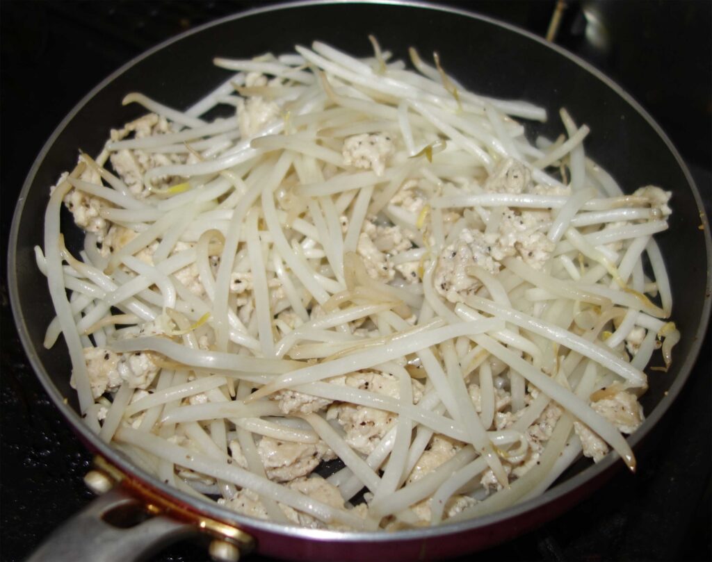 フライパンで鶏ひき肉ともやしを炒めている様子