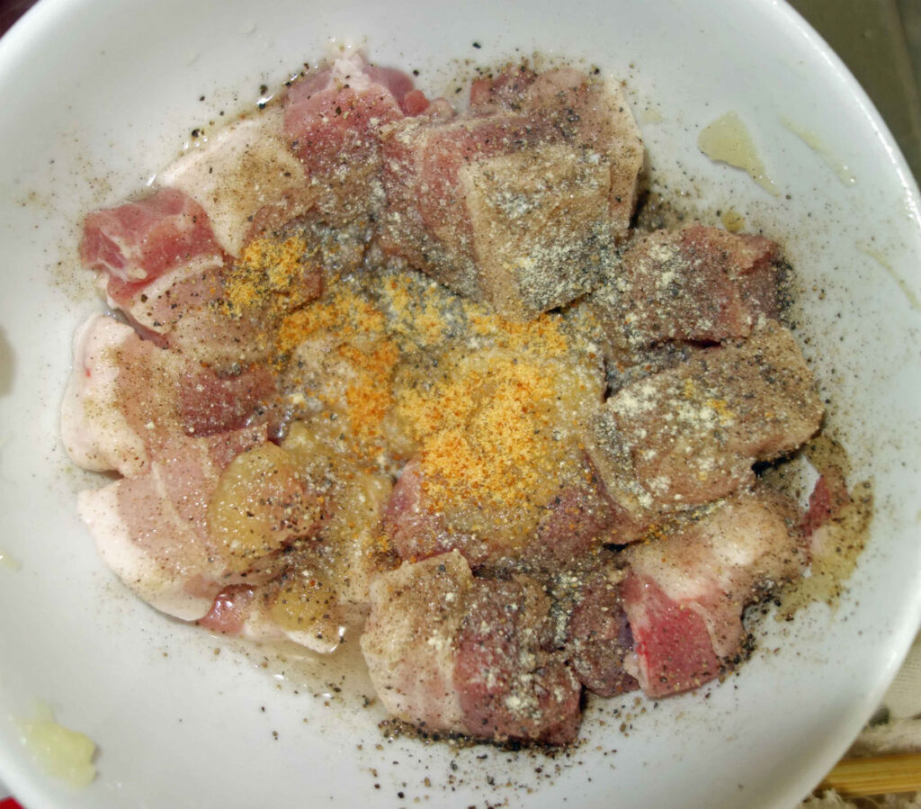 白い器に入った、香辛料がかかった豚肉