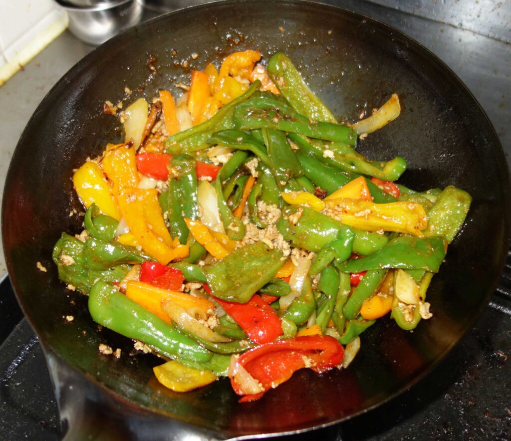 中華鍋で炒めたカラフルなピーマン