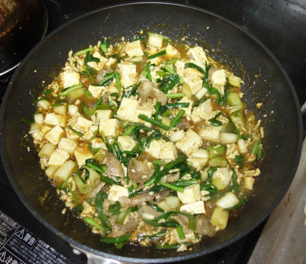 フライパンで調理された豆腐とニラ炒め