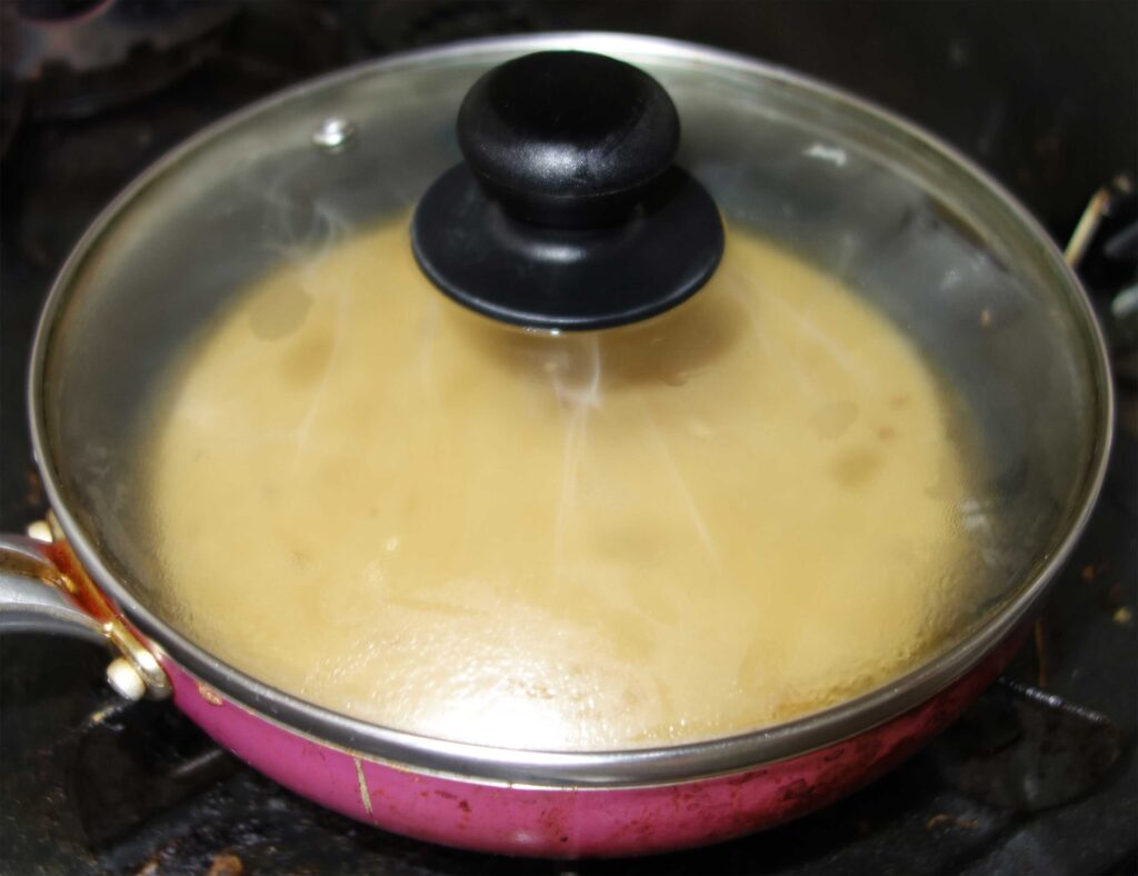 ふた付きフライパンで調理中の料理