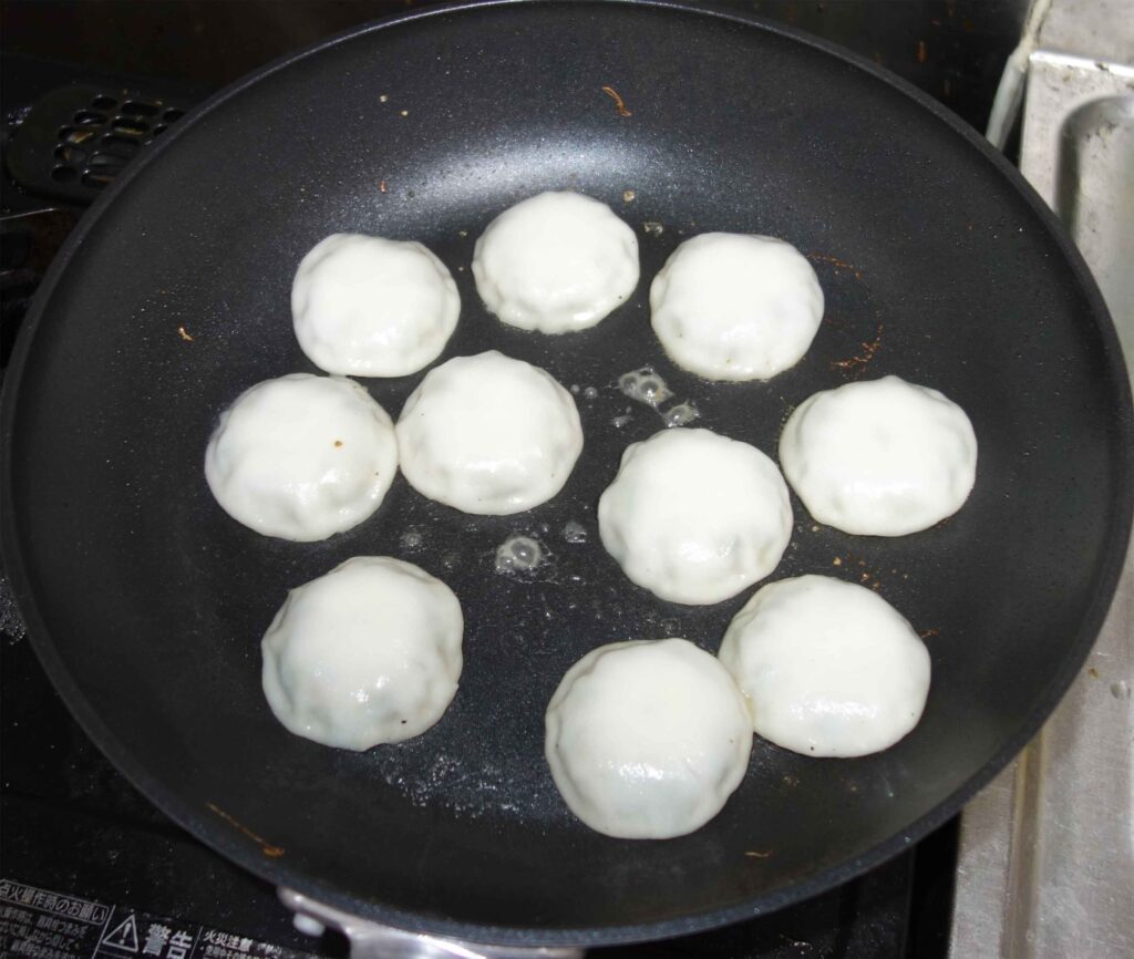フライパンで焼いている白いお饅頭