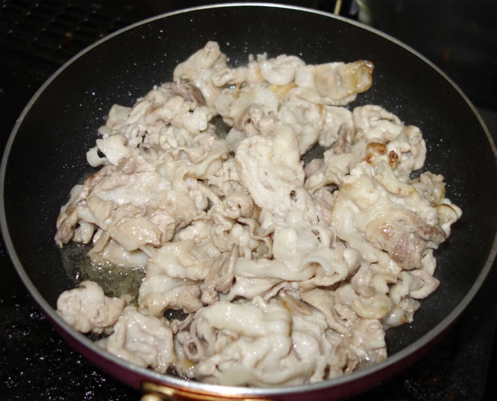 豚肉を炒めているフライパン