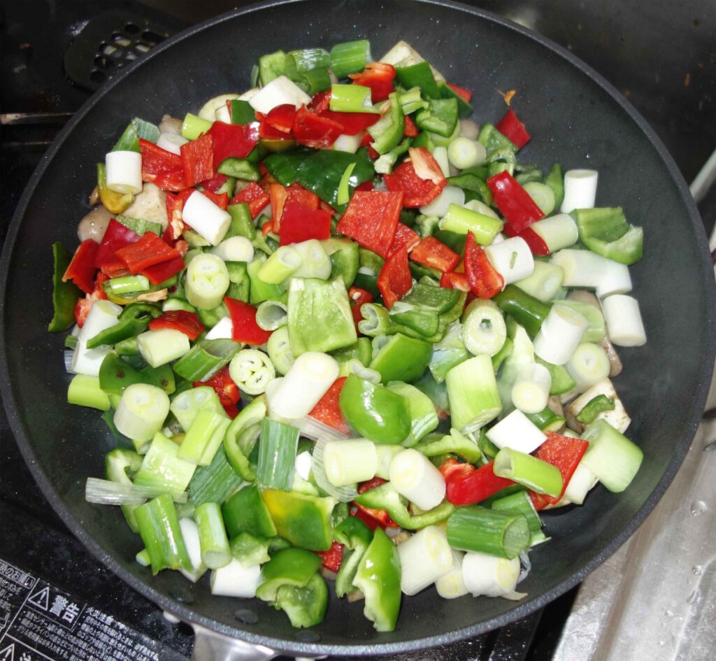 フライパンで調理中の野菜