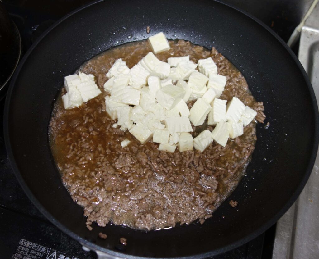 フライパンで調理中の豆腐とひき肉