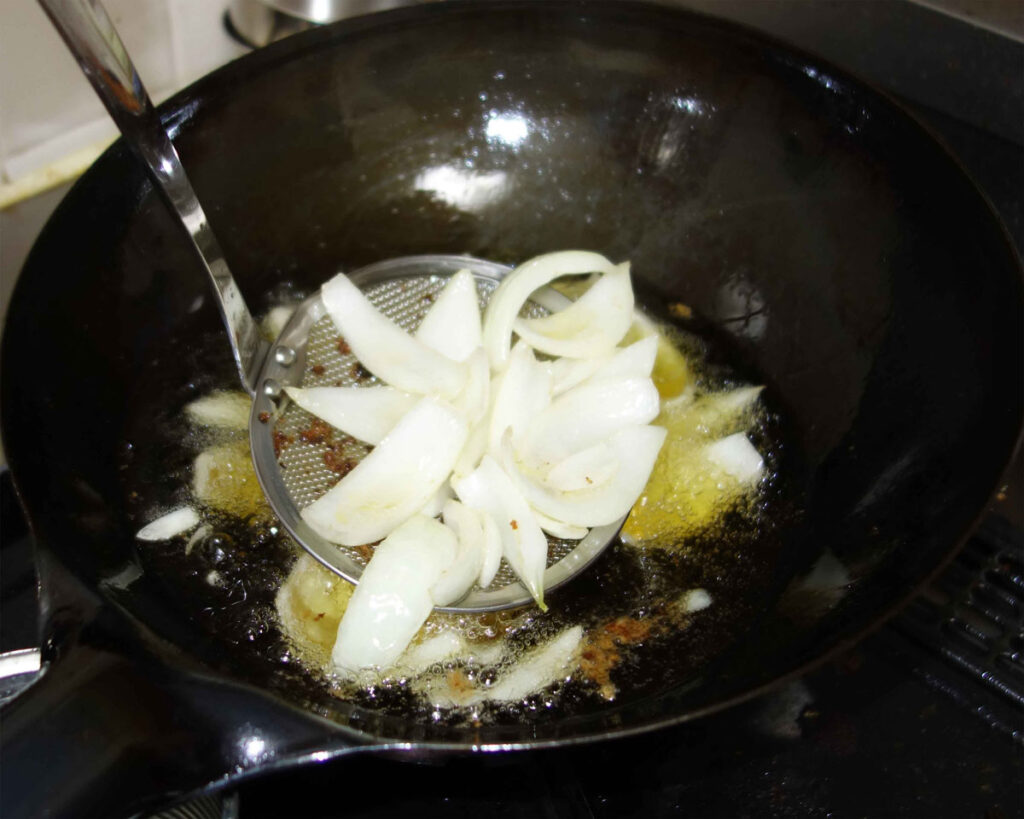 揚げ油で玉ねぎを揚げている様子