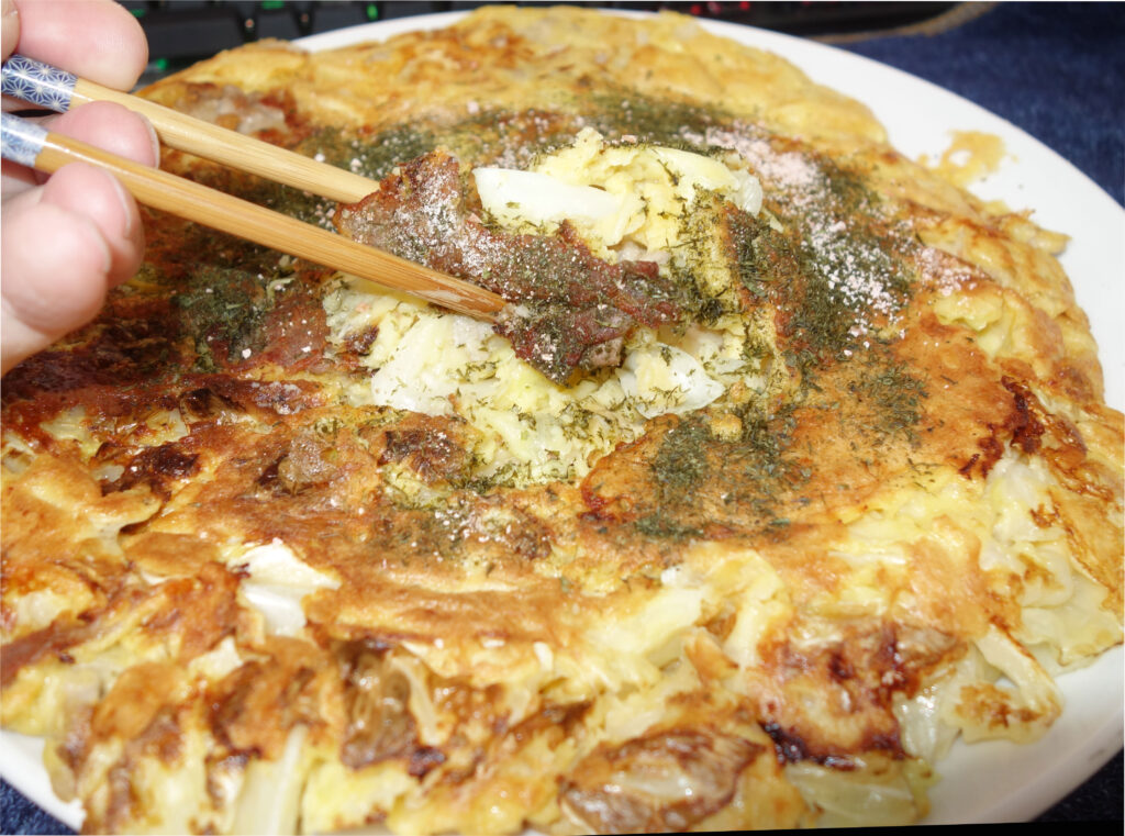 箸でつまんだお好み焼き