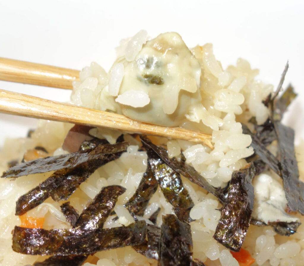 茶碗蒸しをご飯に乗せて箸で持ち上げている様子