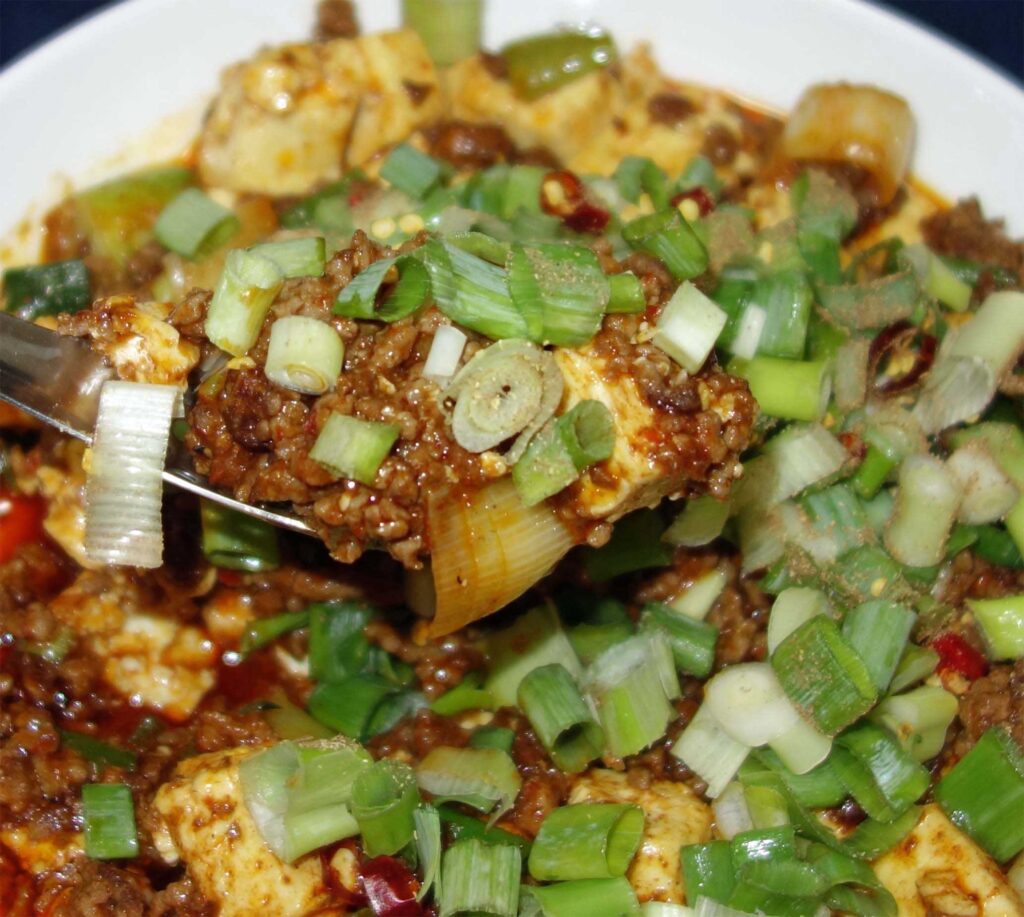 麻婆豆腐をスプーンですくっている写真