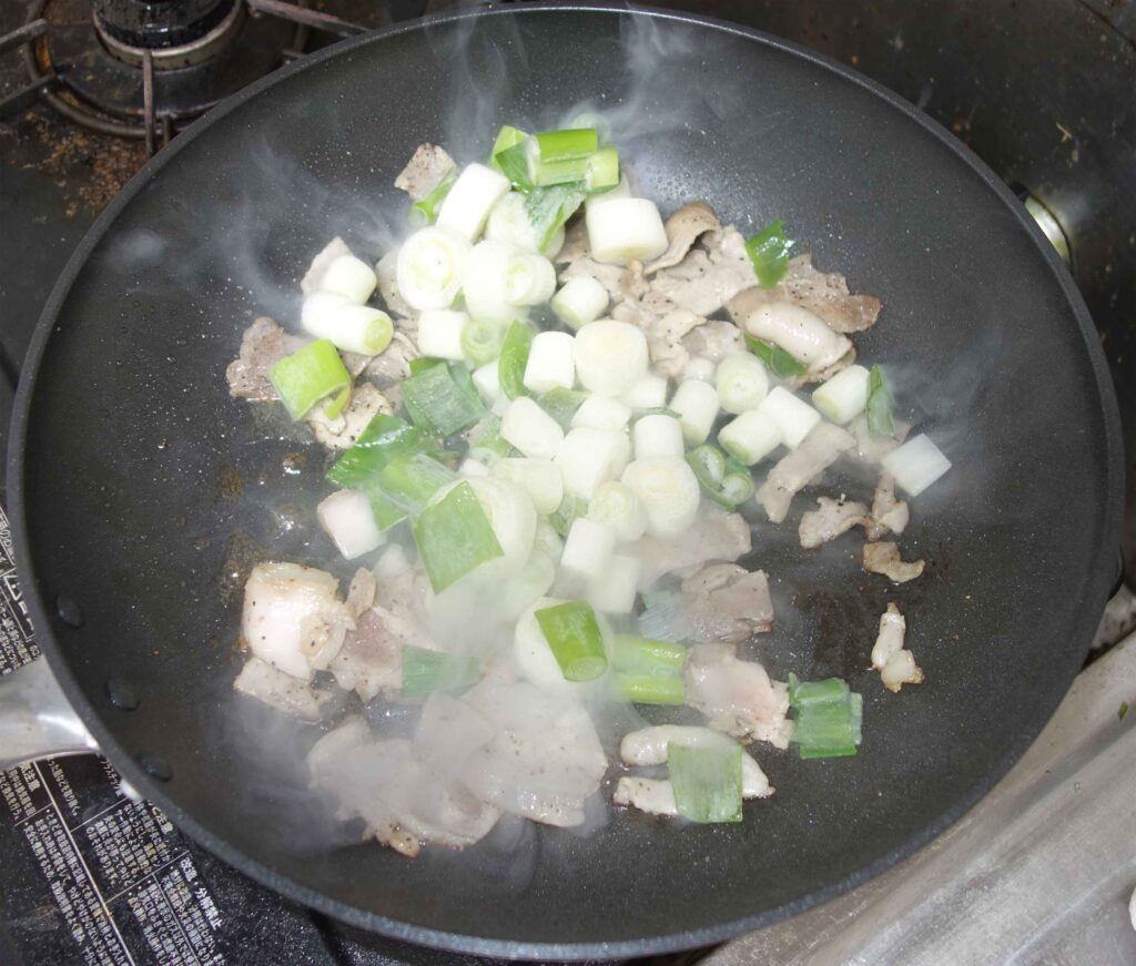 豚肉とネギを炒めている様子