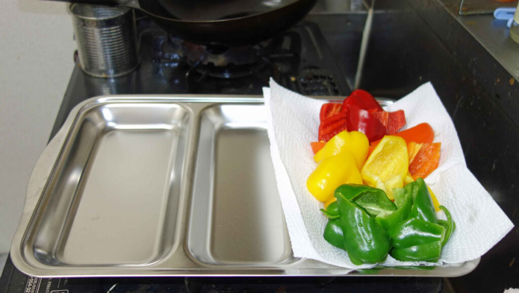 仕切り付きバットに並んだカットされた赤黄緑色のパプリカ