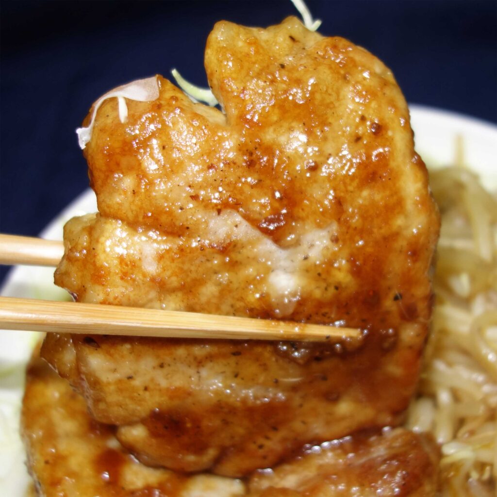 箸で持った豚肉の生姜焼き