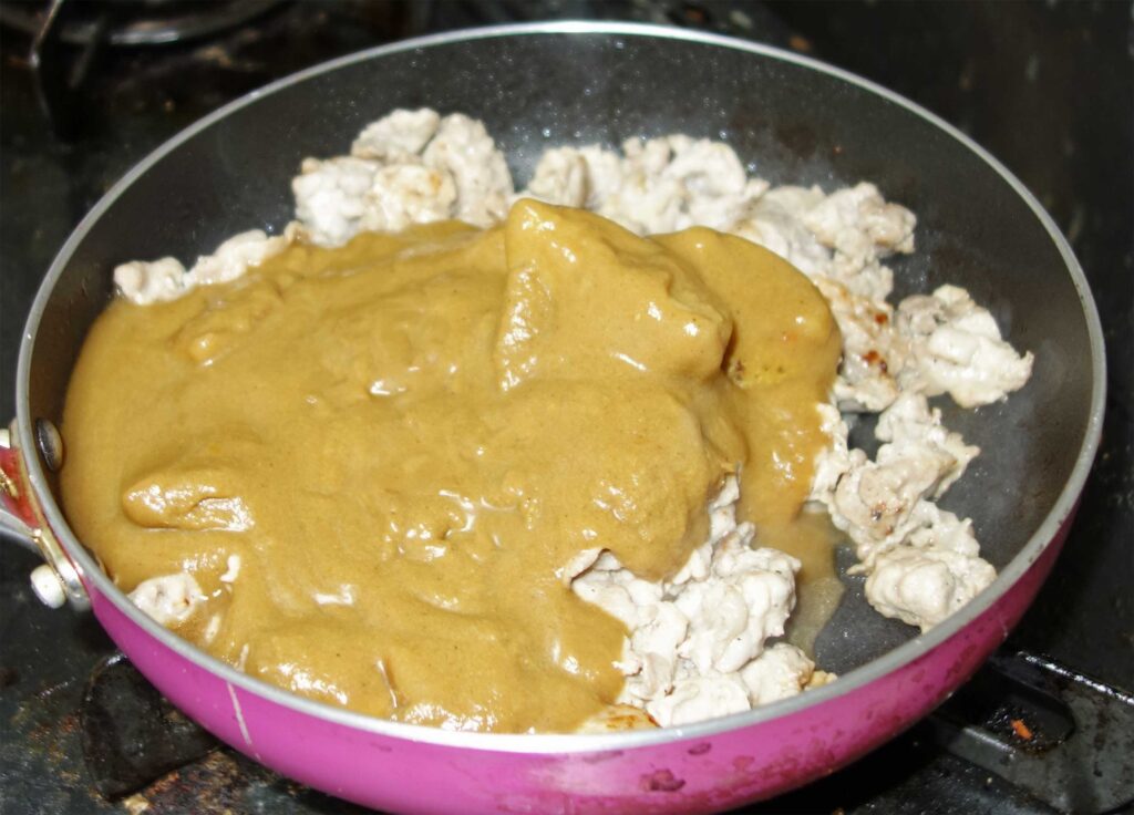 フライパンで鶏ひき肉を炒めてソースをかけている様子