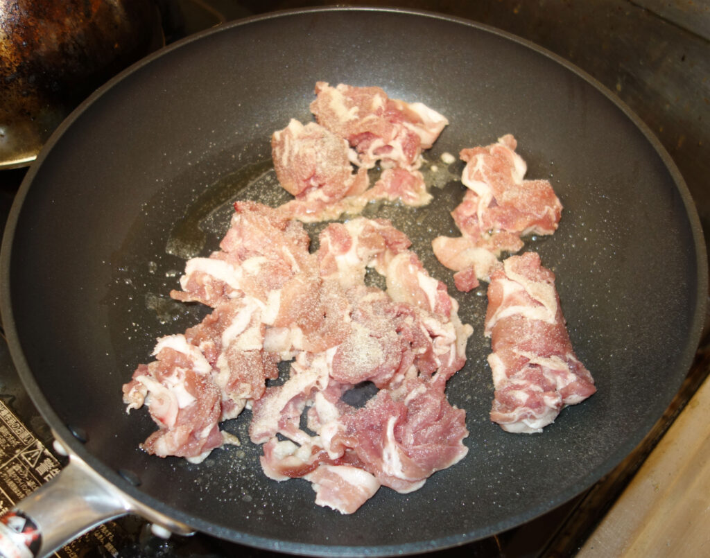 フライパンで炒める豚肉