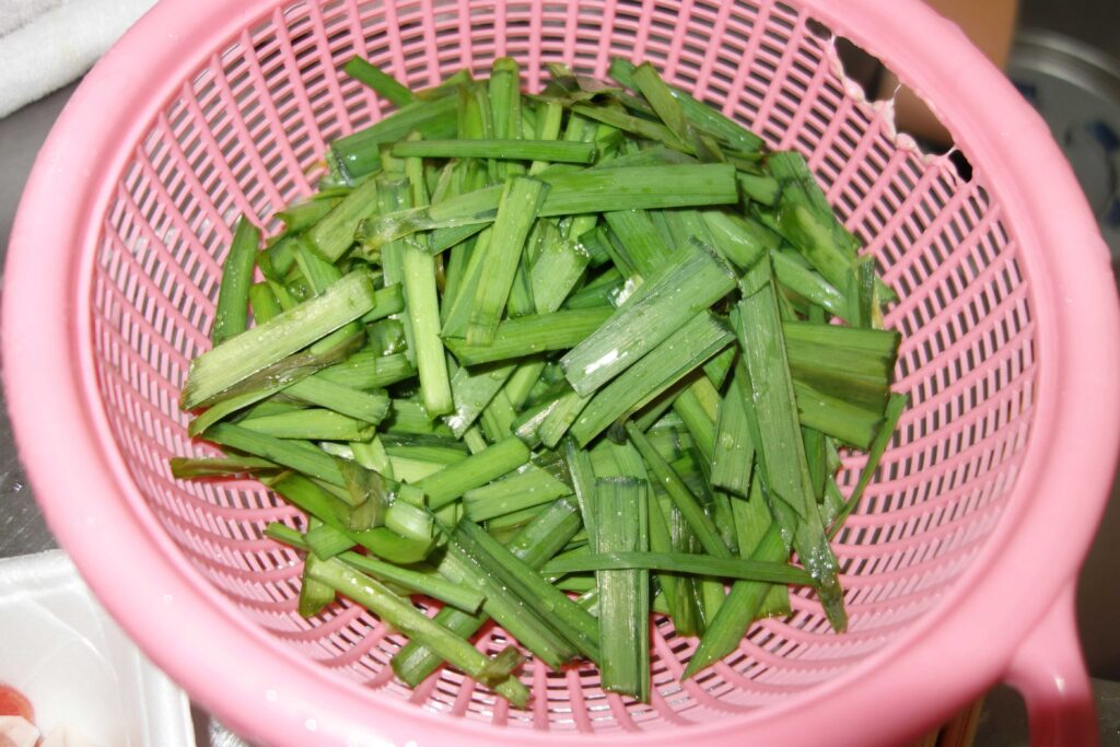 ピンク色のざるに入ったニラ