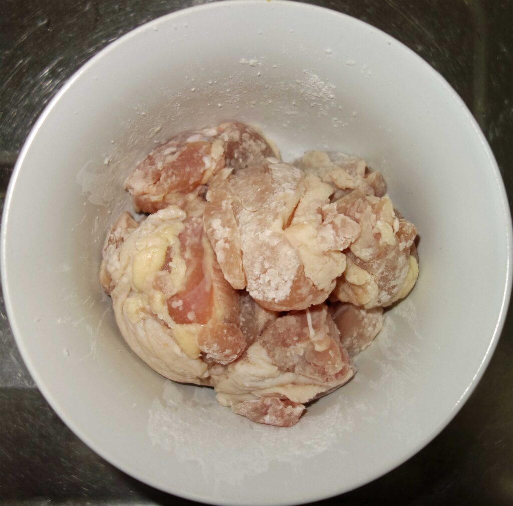 白い器に入った、粉をまぶした鶏肉