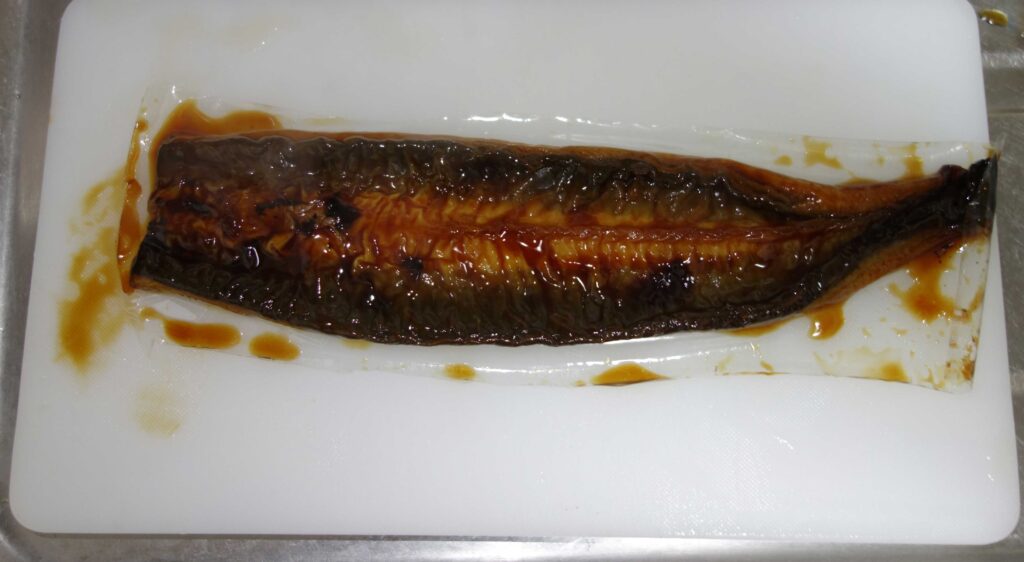 まな板の上のタレがかかったウナギの蒲焼き