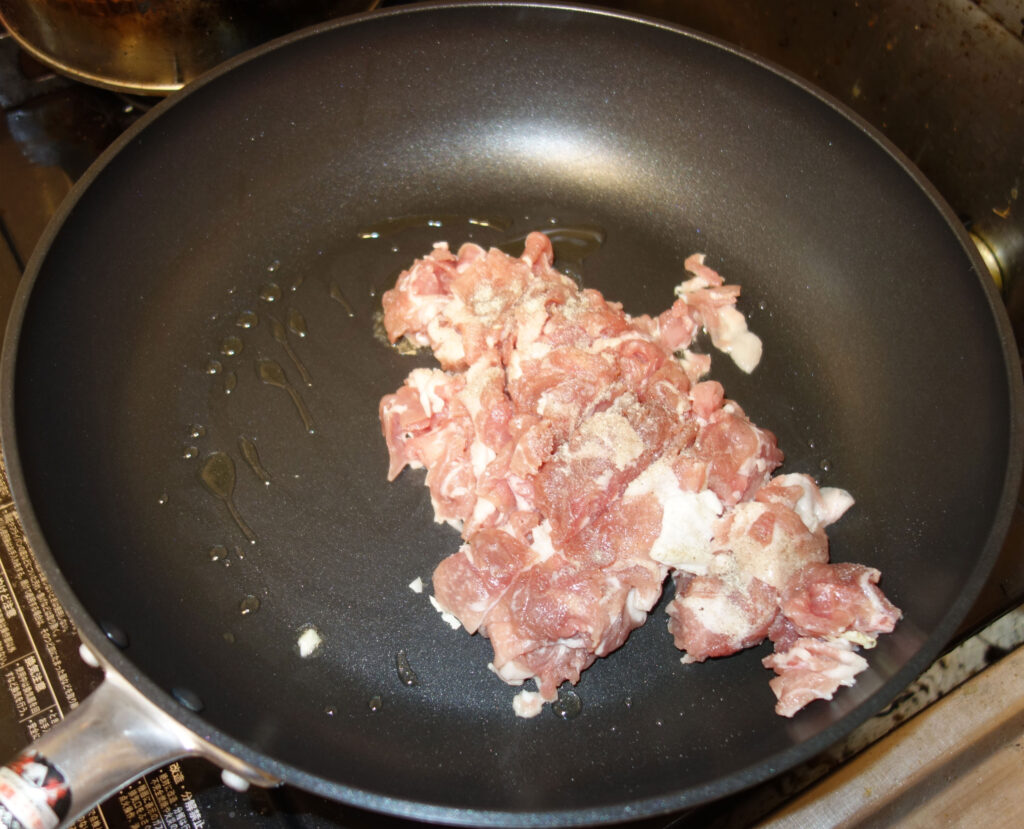 フライパンで豚肉を炒めている様子