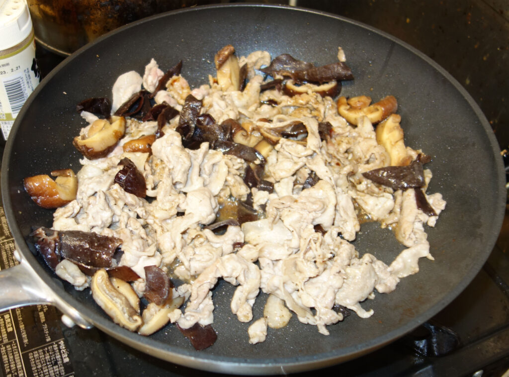 フライパンで炒めた豚肉とキノコ