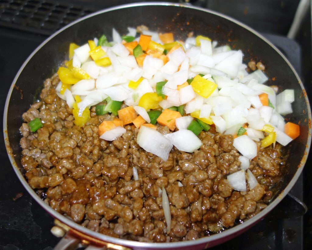 ひき肉と角切り野菜を炒めているフライパン