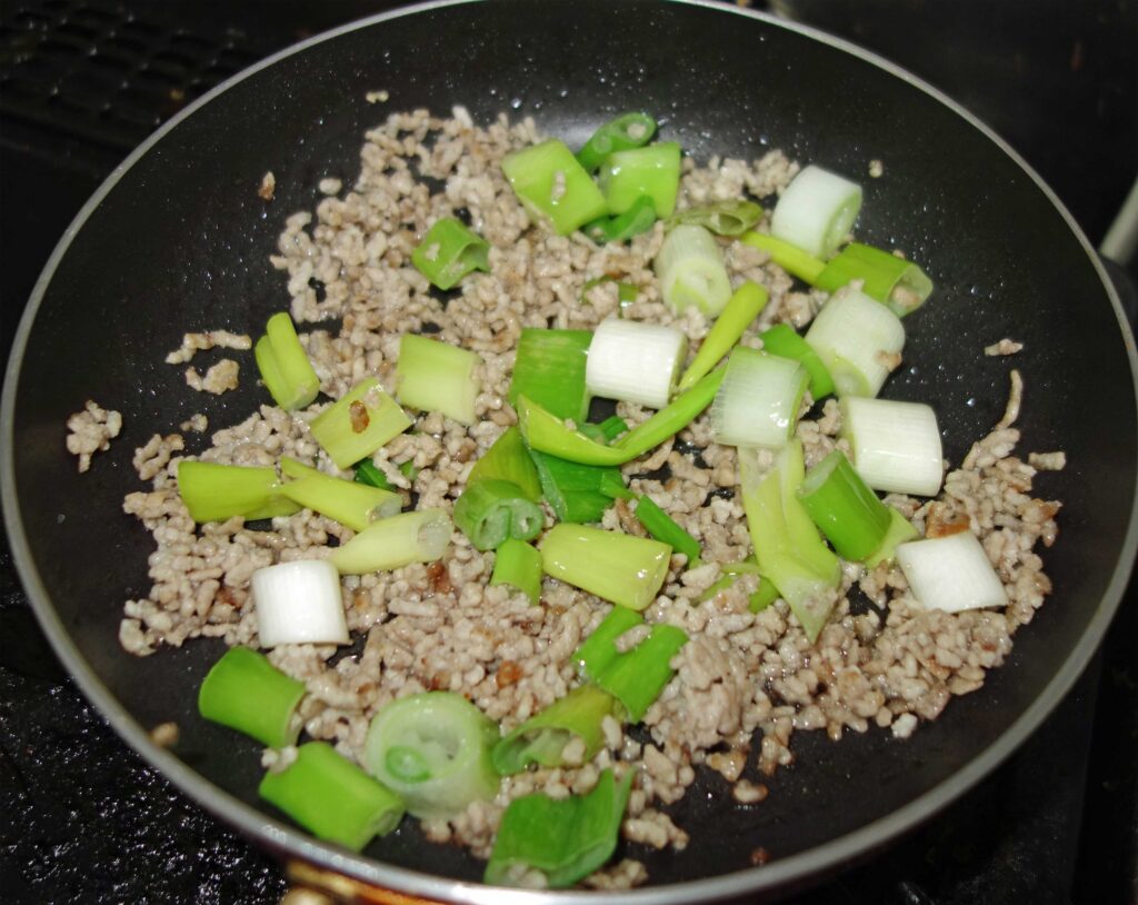 フライパンで炒めたひき肉とネギ