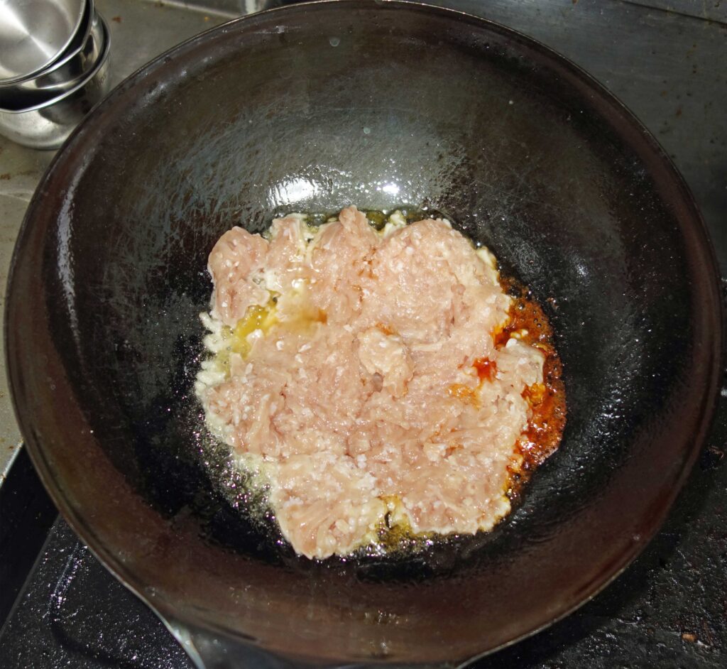 中華鍋で鶏ひき肉を炒めている様子