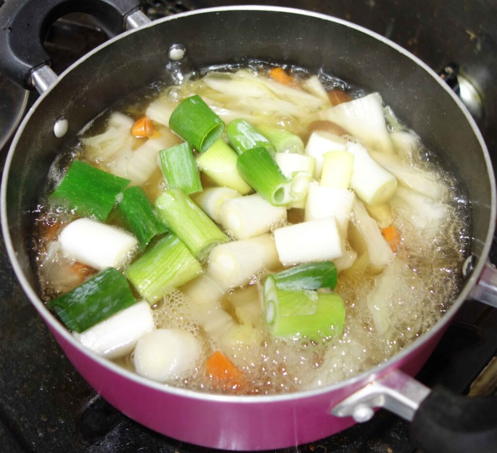 鍋で煮込んでいるネギや白菜などの野菜