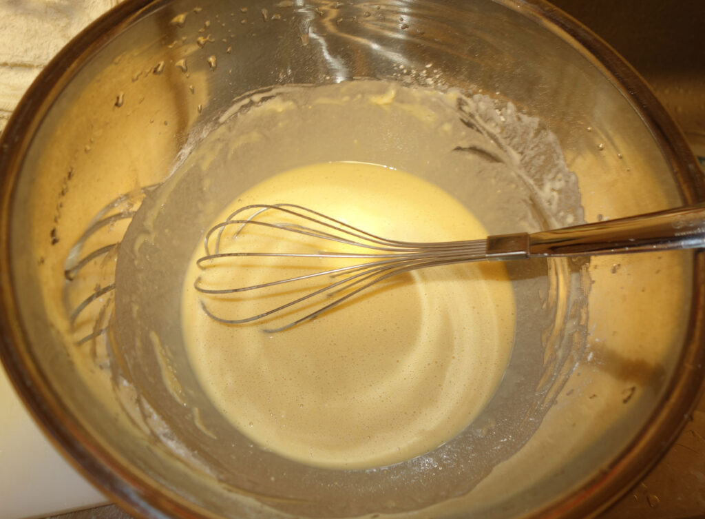 泡立て器で混ぜられたボウルの中の生地