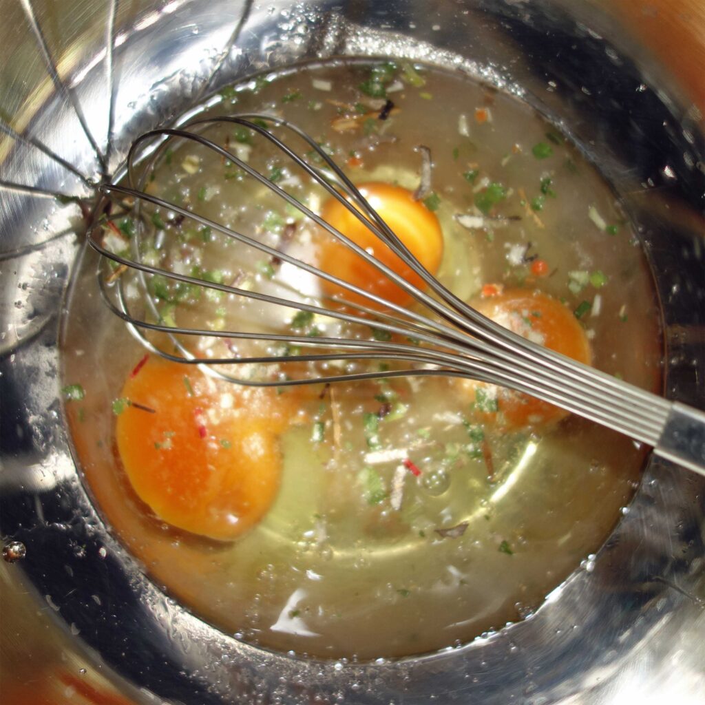 ボウルに入った卵と泡立て器