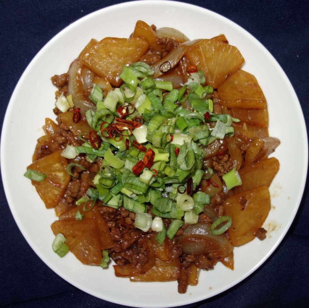 大根とひき肉の煮物ネギと唐辛子添え