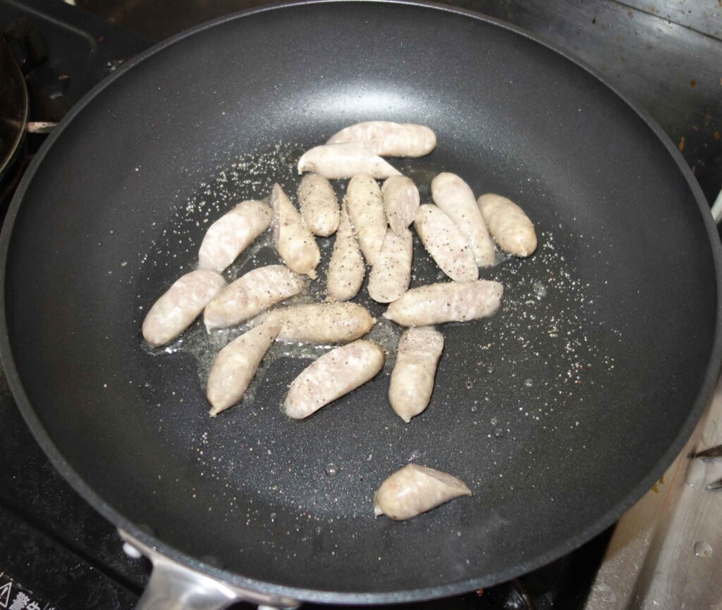 フライパンで焼いている白いソーセージ