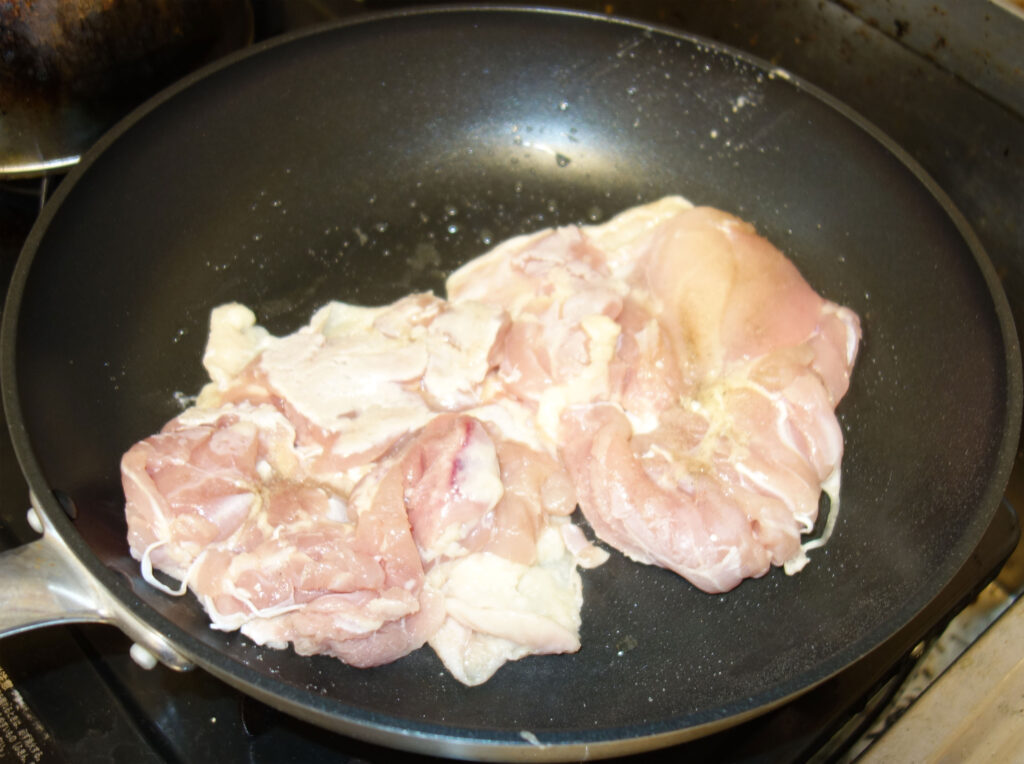 フライパンで焼かれている鶏肉