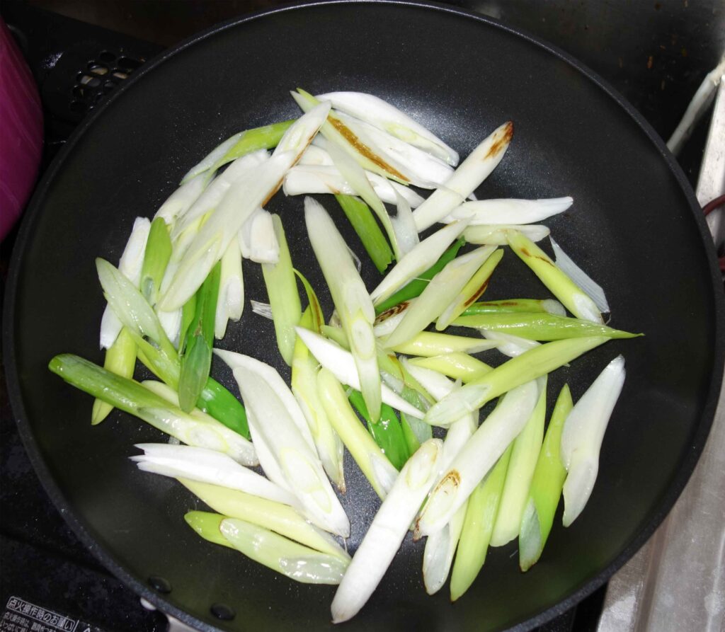 フライパンで炒めたネギ