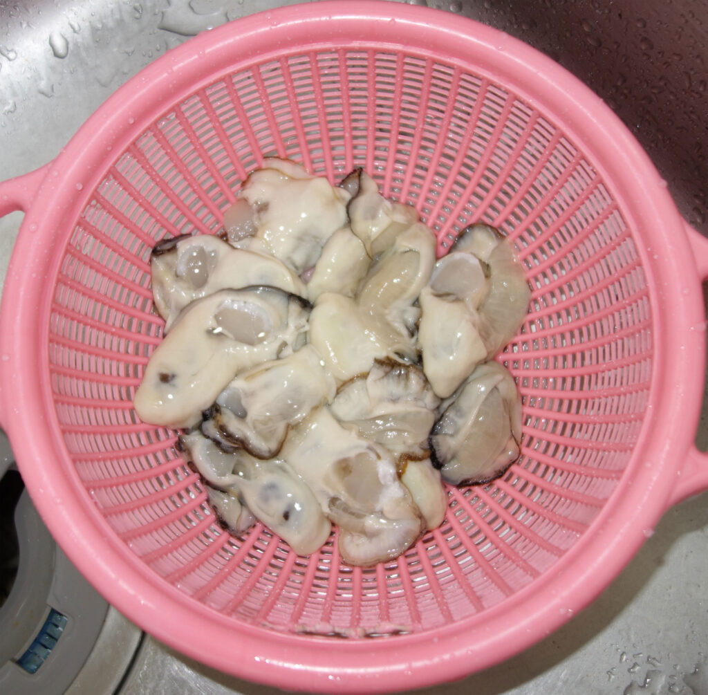 ピンク色のざるに入ったたくさんの牡蠣