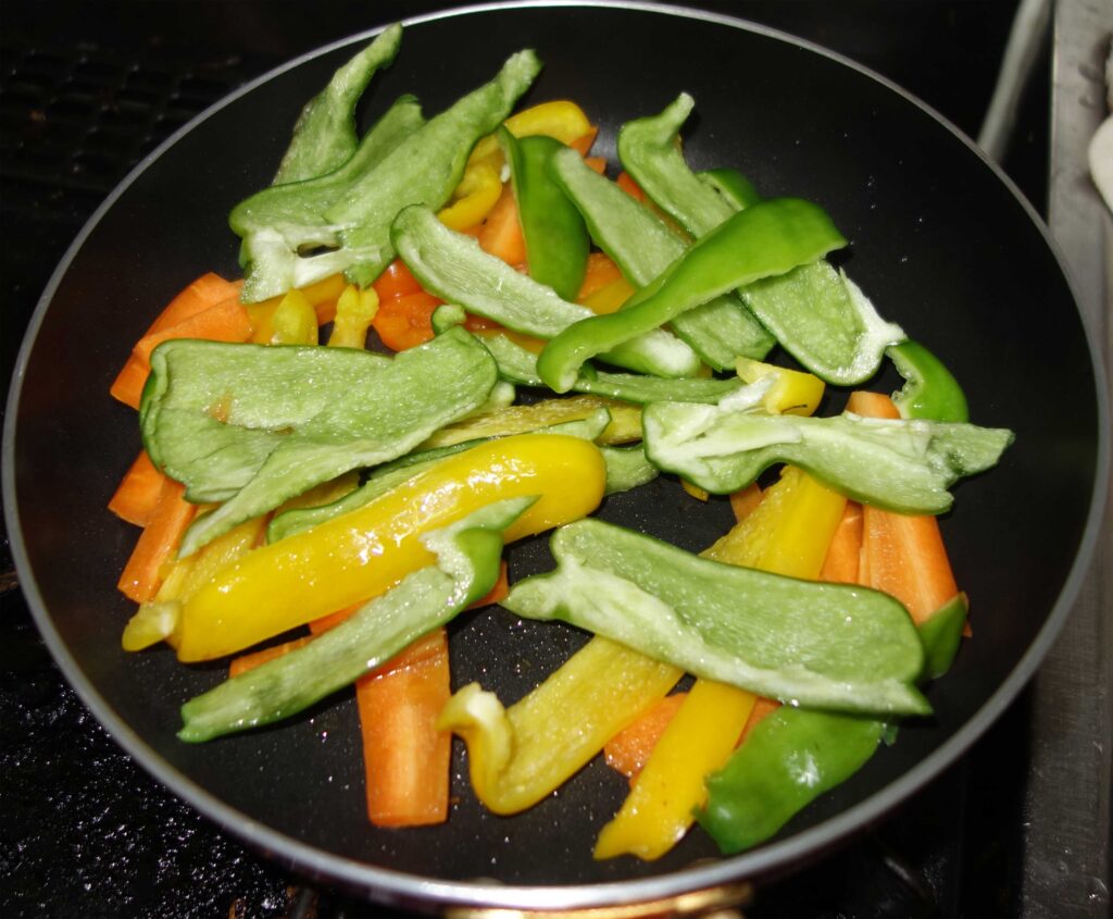 フライパンで調理中のパプリカと人参