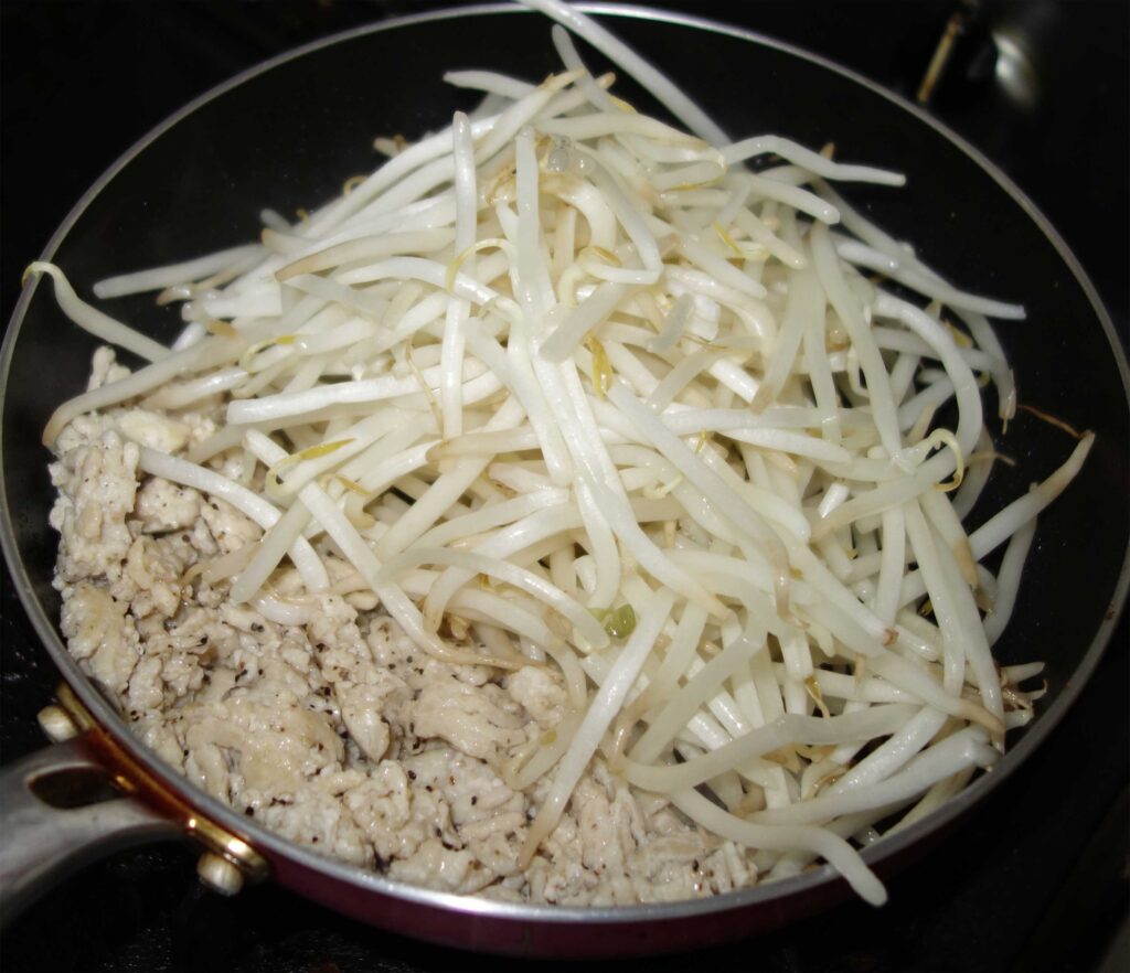 フライパンで鶏ひき肉ともやしを炒めている様子