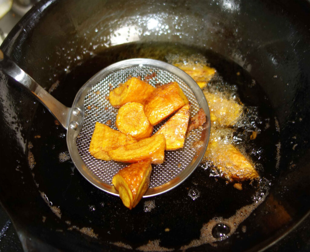 揚げたサツマイモを油切りしている様子